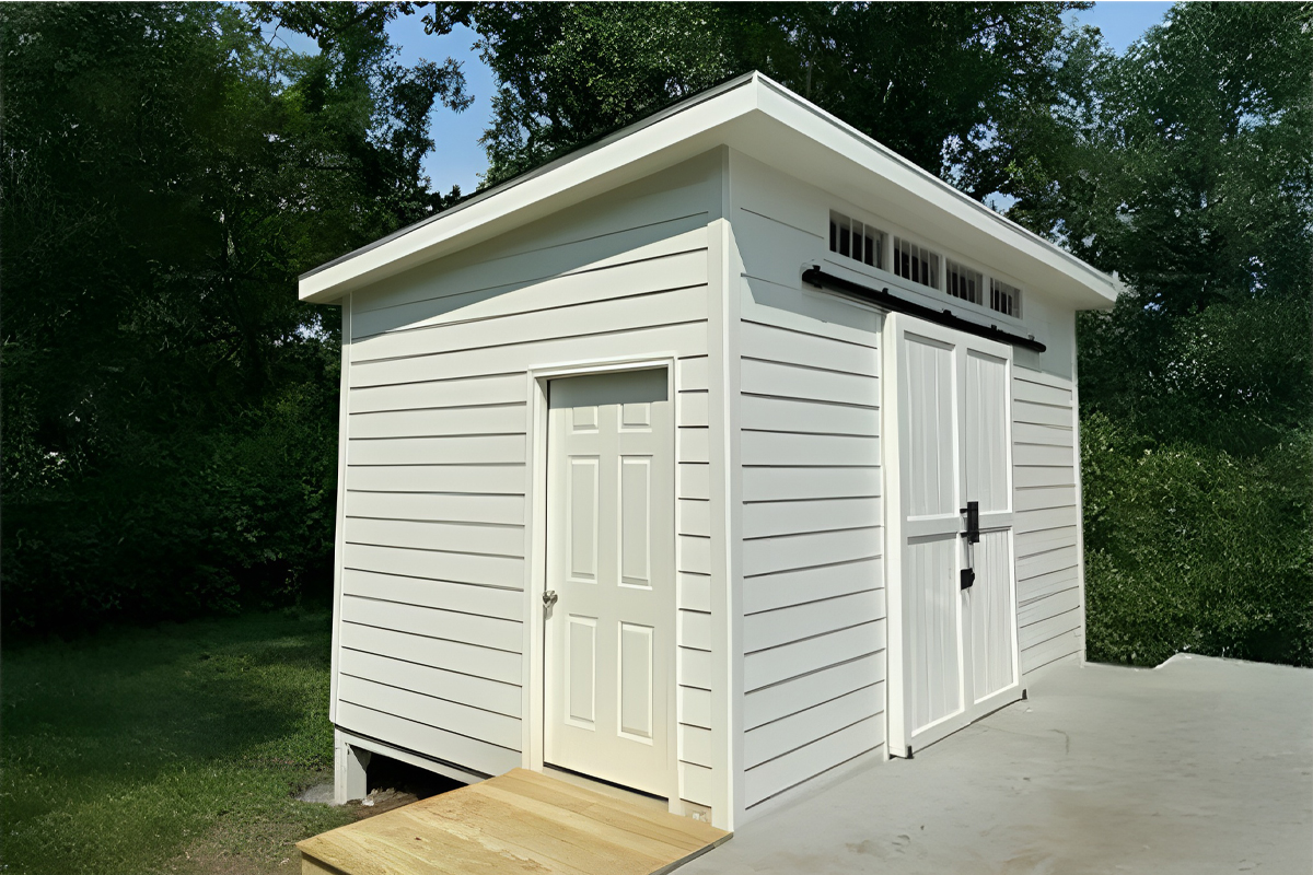 Custom studio with Hardie siding, sliding bard door, and transom windows